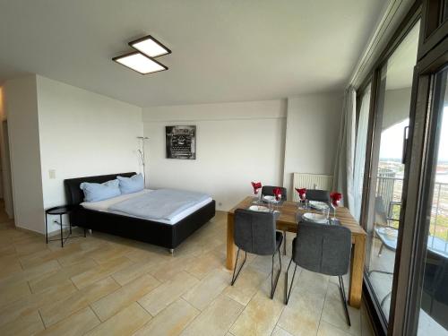 a bedroom with a bed and a table with chairs at Augsburg Hotelturm in Augsburg