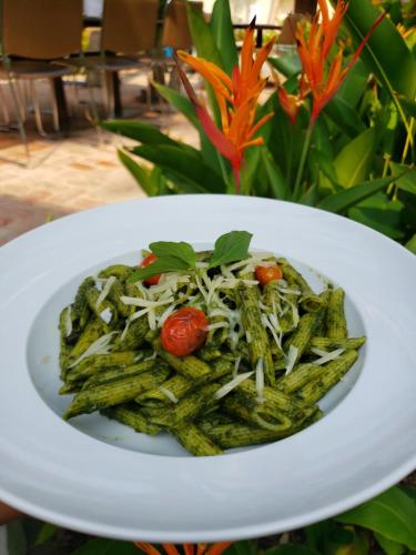 a white plate of pasta with tomatoes and cheese at Natural Relax Villa in Siem Reap
