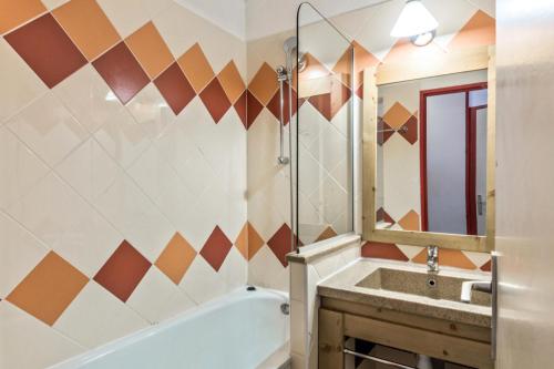 une salle de bain avec une baignoire, un lavabo et un miroir dans l'établissement Résidence Les Fontaines Blanches - maeva Home - Appartement 2 pièces 5 personnes Confort MAE-7288, à Morzine