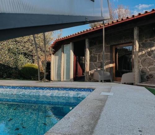 una casa con piscina al lado de un edificio en Casa Eido Do Sorro, en Beiral do Lima