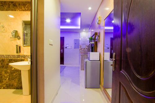 een badkamer met een toilet, een wastafel en een deur bij Swat Hotel Apartments in Dammam