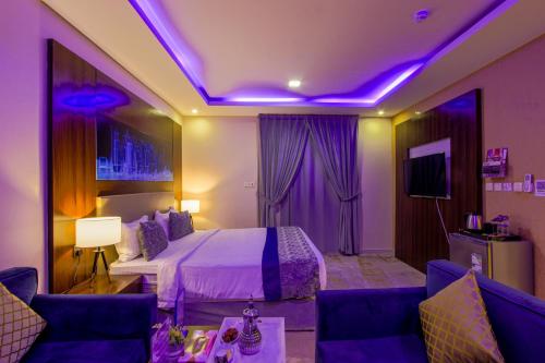 a hotel room with a bed and purple lights at Swat Hotel Apartments in Dammam