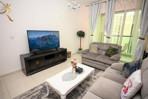 a living room with a couch and a flat screen tv at Al Reems Retreat Victorian 1BR Apartment in Abu Dhabi