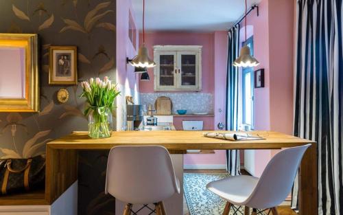 cocina con mesa de madera y 2 sillas blancas en Perfect Studio Home downtown Berlin, en Berlín