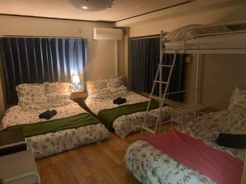 1 dormitorio con 2 literas y escalera en Tokyo KD House 301, en Tokio