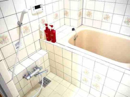 a bathroom with a bath tub with two ketchup bottles at Tokyo KD House 301 in Tokyo