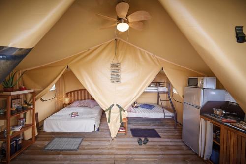 Cette tente comprend 2 lits et un ventilateur de plafond. dans l'établissement Camping Chantemerle, à Bédouès