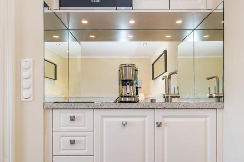 a kitchen with a sink and a mirror at App Kampen in Kampen