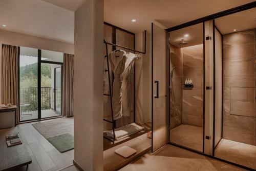 ein Bad mit einer ebenerdigen Dusche neben einer Glastür in der Unterkunft Creek Moganshan Design B&B in Deqing