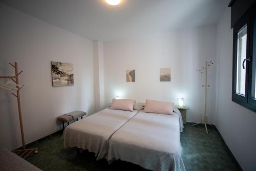 a bedroom with a bed with pink pillows on it at Casa Ángeles in Teruel