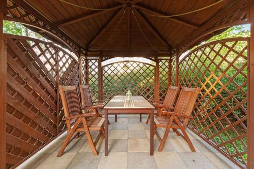 a wooden table and chairs in a gazebo at Patio Mare - Garden by Grand Apartments in Sopot