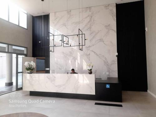 uma casa de banho com uma parede de mármore com uma pessoa dentro em Studio charmoso muito bem localizado em São Paulo