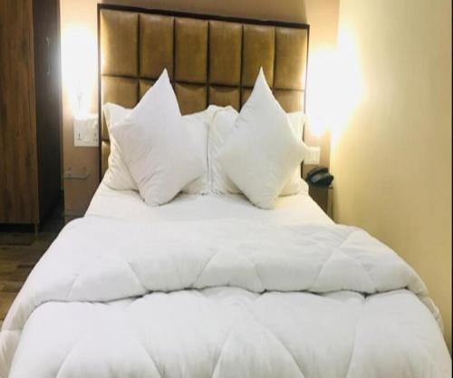 Elle comprend un grand lit blanc avec des oreillers blancs. dans l'établissement StayApart - Aasmaa Farm Stay, à Ābādpura