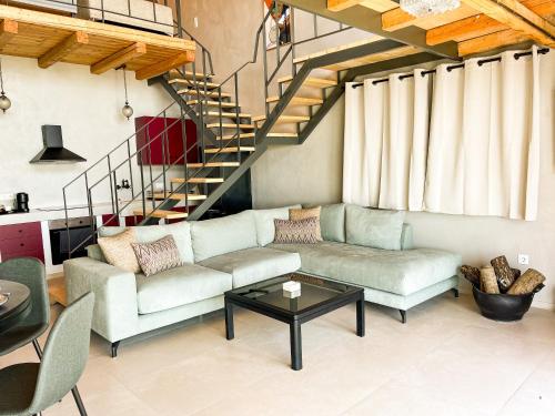 a living room with a couch and a staircase at Modern Stone Villas with Swimming Pool in Aliveri