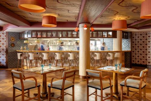 restauracja ze stołami i krzesłami oraz bar w obiekcie Le Grand Mazarin w Paryżu