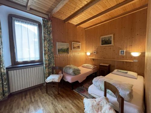 a room with two beds and a window at Appartamenti Casa Albi in Pinzolo