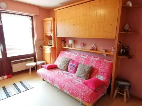 Schlafzimmer mit einem Bett mit rosa Bettwäsche in der Unterkunft Appartement Le Grand-Bornand, 1 pièce, 4 personnes - FR-1-241-221 in Le Grand-Bornand
