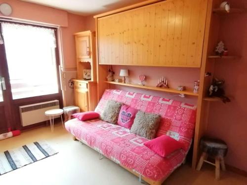 a bedroom with a bed with pink sheets at Appartement Le Grand-Bornand, 1 pièce, 4 personnes - FR-1-241-221 in Le Grand-Bornand