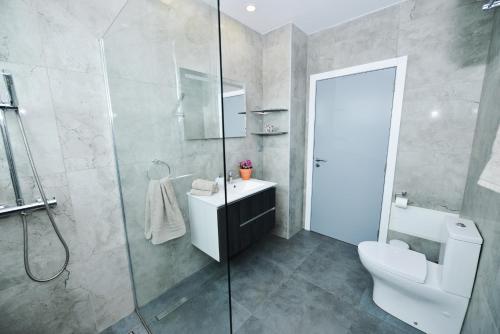 a bathroom with a shower and a toilet and a sink at Casa Mar Azul in Arco da Calheta