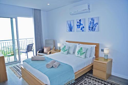 a bedroom with a large bed and a balcony at Casa Mar Azul in Arco da Calheta