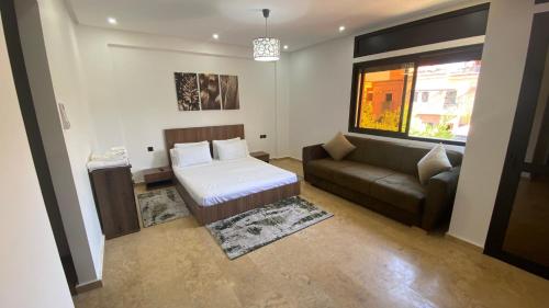 a bedroom with a bed and a couch and a window at Villa Targa in Marrakesh