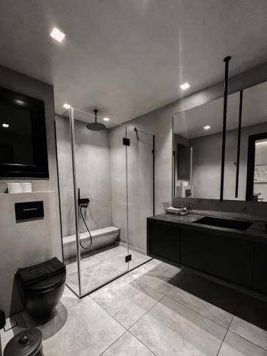 y baño con ducha, aseo y lavamanos. en CASAGOLD Glyfada Luxury Apartment Near The Sea, en Atenas