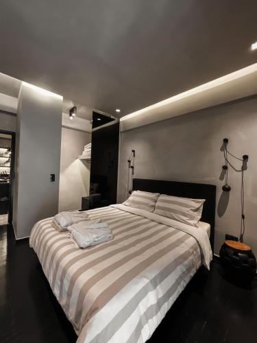 アテネにあるCASAGOLD Glyfada Luxury Apartment Near The Seaのベッドルーム1室(大型ベッド1台、ストライプ毛布付)