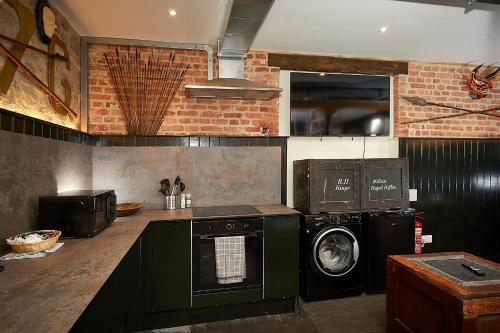 a kitchen with a washing machine and a washer at Snobs and Rebels Apartments in Shaftesbury