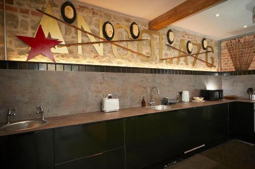 a kitchen with a counter with clocks on the wall at Snobs and Rebels Apartments in Shaftesbury