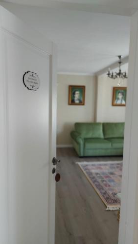 a living room with a green couch and a door at Conacul Poetilor in Gura Rîului