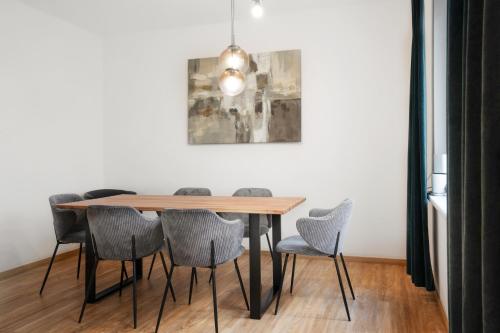 a dining room table with chairs and a painting on the wall at easy flat Villach main plaza in Villach