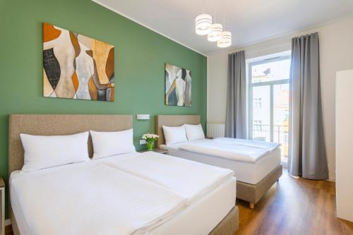 2 camas en una habitación con paredes verdes en Hidden Art Boutique Residence, en Praga