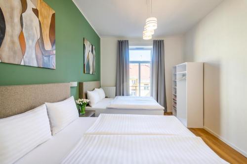 two beds in a room with green walls at Hidden Art Boutique Residence by Dwellfort in Prague