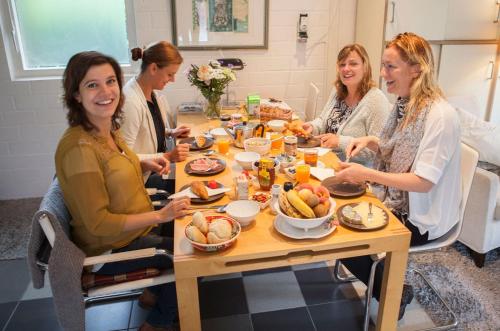 a group of women sitting around a table eating food at Cottage Markdal in Breda