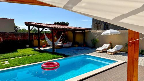 a pool with a red frisbee in a yard at La Casita Nazaré - private pool in Nazaré