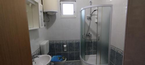 y baño con ducha y lavamanos. en Apartment Štrbić, en Ploče