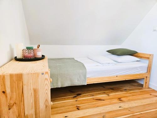 een bed in een kamer met een houten tafel bij Sunset Kaszuby in Chrztowo