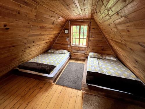 Habitación con 2 camas en una cabaña de madera en Silamalas, en Tukums