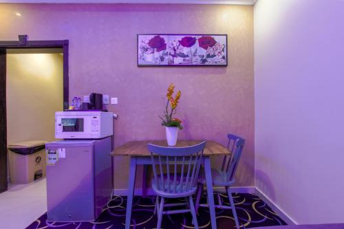 eine kleine Küche mit einem Tisch und einer Mikrowelle in der Unterkunft Maskan Al Dyafah Hotel Apartments 2 in Dammam