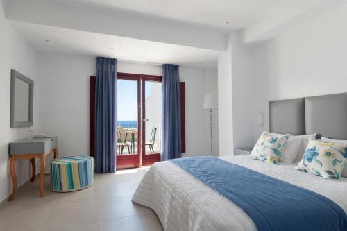 um quarto com uma cama e vista para o oceano em MAR n MAR CROWN HOTEL-SUITES em Kamari