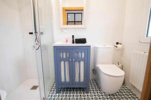 ein Badezimmer mit einem blauen Schrank neben einem WC in der Unterkunft Casa Rural Hacienda Montorio in Montorio