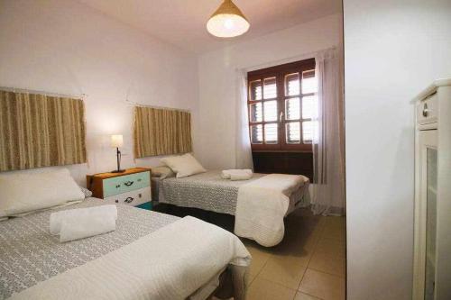 a bedroom with two beds and a window at Cotton House in Playa Blanca
