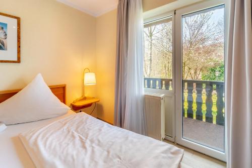 a bedroom with a bed and a window with a balcony at Bierenbacher Hof in Nümbrecht