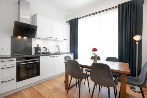 a kitchen with a dining room table and chairs at easy flat Villach main plaza in Villach