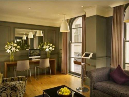 ein Wohnzimmer mit einem Sofa und einem Tisch in der Unterkunft Well Presented Spacious 1 Bed Flat In Kensington in London
