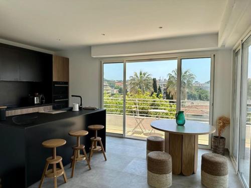 - une cuisine avec une table et quelques tabourets dans l'établissement NEUF - Appartement neuf proche plages - Clim, WIFI, à Antibes