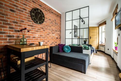 - un salon avec un canapé et un mur en briques dans l'établissement Apartament Ducha N°9, à Toruń