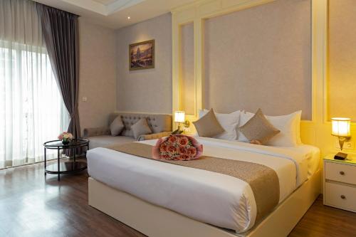 a hotel room with a large bed and a couch at Anik Boutique Hotel in Phnom Penh