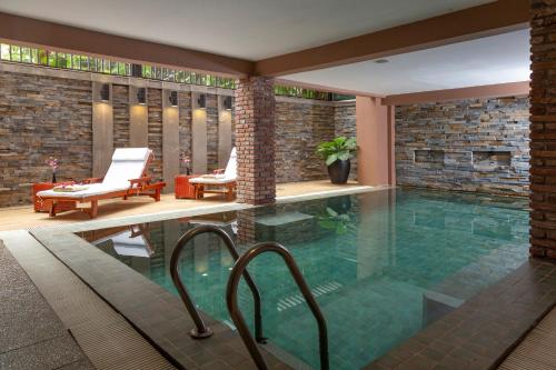 a swimming pool in a house with two chairs at Anik Boutique Hotel in Phnom Penh
