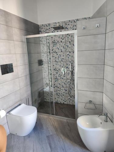 a bathroom with a shower and a toilet and a sink at Gradini Partenopei in Naples